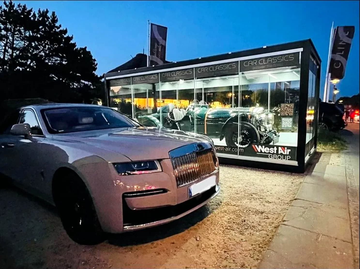 REINHART Gallery Car Classics bei Nacht: Rolls-Royce im beleuchteten Inneren, dunkler Garten als Kontrast. Projektfoto.