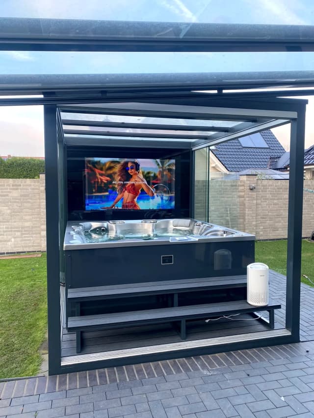 REINHART Spa mit Lamellendach im Wohngarten, TV und Whirlpool sichtbar
